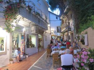 a group of people sitting at tables in an alley at Apartamento Pleno Centro Marbella in Marbella