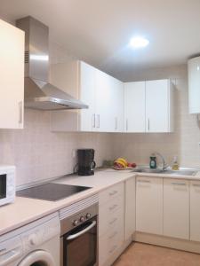 eine Küche mit weißen Schränken und einem Herd mit Backofen in der Unterkunft Apartamento Pleno Centro Marbella in Marbella