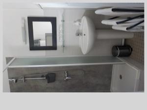 uma casa de banho com um espelho e um lavatório em lOberge em Mios