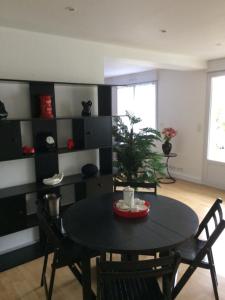a dining room with a black table and chairs at Appartement Granville in Granville