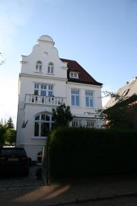 a white house with a red roof at Ferienwohnung Bamberger in Lübeck