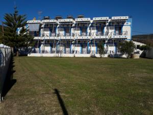 ein großes weißes Gebäude mit einem Rasen davor in der Unterkunft Panorama Hotel in Ammoudia