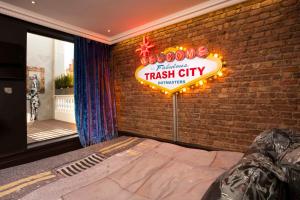 um quarto com um letreiro de néon numa parede de tijolos em The Exhibitionist Hotel em Londres