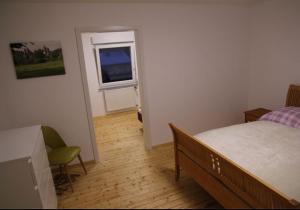a small bedroom with a bed and a window at Ferienhaus am Kreuzberg - Nürburgring in Ulmen