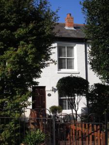 uma casa branca com uma cerca à frente. em Pretty Victorian Cottage em Portsmouth