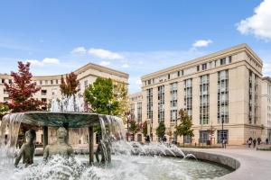 una fuente frente a un edificio con dos estatuas en 5ème Ciel - Première Conciergerie, en Montpellier