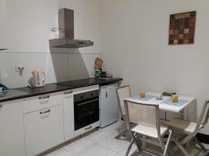 a kitchen with a stove and a table with chairs at Residenza dell'Orto in Chiavari