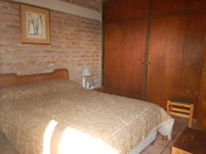 a bedroom with a bed and a brick wall at Complejo Duque in Puerto Madryn