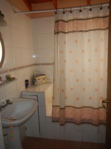 a bathroom with a sink and a shower curtain at Complejo Duque in Puerto Madryn