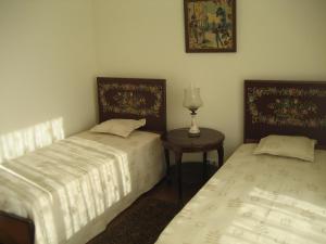 2 camas en una habitación con una mesa y una lámpara en Yourpenthouseinmadeira en Funchal