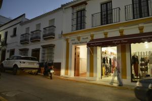 una persona caminando por una calle frente a una tienda en Casa Rural Pueblos Blancos, en Bornos