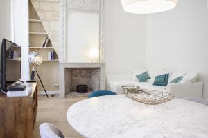 uma sala de estar com uma mesa e um sofá em Appartement Hypercentre - Le Ruat em Bordeaux