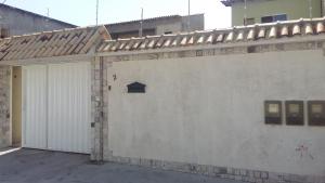 un garaje con una pared blanca y una puerta en Casa de Temporada no Centro de Cabo Frio, en Cabo Frío