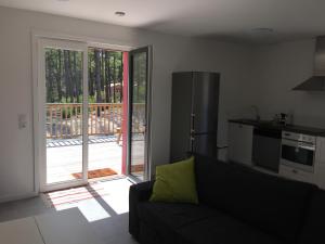 a living room with a couch and a kitchen at Villa Orchidee in Lacanau-Océan