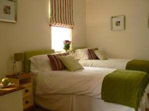 two beds sitting next to each other in a room at Ashberry Guest House in Penrith