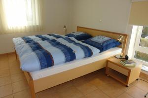 ein Bett mit blauen und weißen Decken und Kissen darauf in der Unterkunft Amselstern Binz in Binz