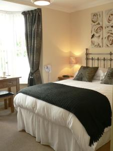 a bedroom with a large bed with a black blanket at Ashberry Guest House in Penrith
