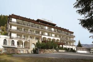 a large white building with a sign on it at Hotel Derby - Room Only in Davos