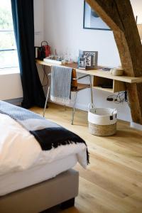 ein Schlafzimmer mit einem Bett und einem Schreibtisch in einem Zimmer in der Unterkunft Les Chambres de Martin in Brüssel
