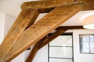a wooden beam in a room with windows at Les Chambres de Martin in Brussels
