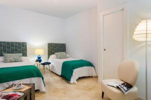 グラナダにあるGenteel Home Tablasのベッドルーム1室(ベッド2台、テーブル、椅子付)