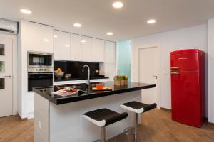 a kitchen with a red refrigerator and a counter with stools at Genteel Home Tablas in Granada