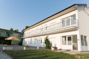 a white building with a balcony on the side of it at Apartments O Sole Mio in Vukovar