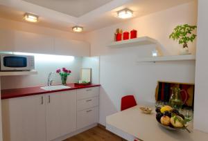 a kitchen with white cabinets and a bowl of fruit on a table at Zimmer In Yuvalim in Yuvallim