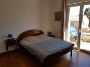 um quarto com uma cama e uma grande janela em Villa Calliste em Saint-Laurent-du-Var