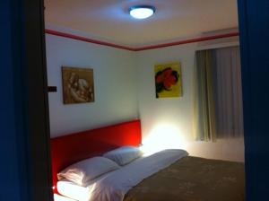 a bedroom with a bed with a red headboard at Apartments Mimoza in Slano