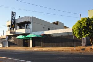 un bâtiment avec un parasol vert dans une rue dans l'établissement Hotel Carolina Plaza, à Uberaba