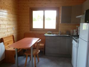 a small kitchen with a table and a refrigerator at Chalet la Noisetiere Armalou in Pouilly-sur-Loire +18 photos
