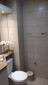 y baño con aseo blanco y ducha. en Apartamento Flat, en Gramado