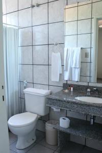a bathroom with a toilet and a sink and a mirror at Hotel Fazenda Bela Vista in César de Pina