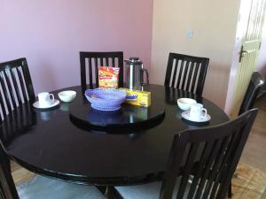 Pumzika Place في نيروبي: طاولة طعام مع طاولة سوداء وكراسي