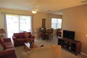 a living room with a couch and a tv at Formosa Garden Pool Home in Orlando