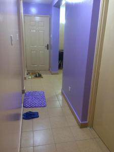 a hallway with a purple door and a tile floor at Pumzika Place in Nairobi