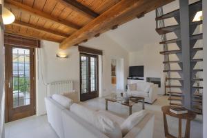 un soggiorno con divano bianco e scala a chiocciola di Villa Manziana a Manziana