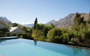 a swimming pool with mountains in the background at Keren's Vine Guesthouse in Stellenbosch