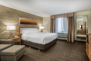 una camera d'albergo con un grande letto e un divano di Holiday Inn Saratoga Springs, an IHG Hotel a Saratoga Springs