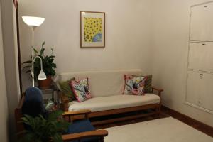 ein Wohnzimmer mit einem Sofa und einer Lampe in der Unterkunft Mary's House in Carnaxide