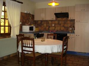 a kitchen with a table and some chairs and a kitchen with a table at Le Sonnenglanz in Beblenheim