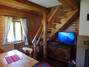 a living room with a staircase and a television in a cabin at Chata pod Belianskymi Tatrami in Ždiar