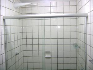 a bathroom with a shower with white tiled walls at Recanto das Saíras in Morretes +41 photos
