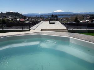 a swimming pool with a view of a mountain at Dein Haus Hotel y Departamentos in Puerto Varas