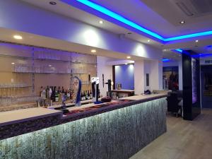 a bar in a restaurant with purple lights at The Charles Hotel in Chatham