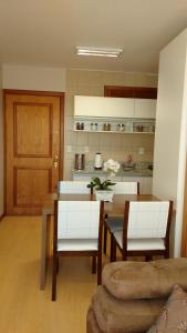 sala de estar con mesa y sillas y cocina en Apartamento Flat, en Gramado