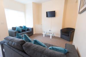 uma sala de estar com um sofá e uma televisão em Campbell House em Gainsborough
