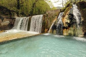 einem Wasserfall mit einem Pool mit Wasser davor in der Unterkunft Neraides in Kato Loutraki