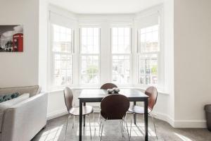 a dining room with a table and chairs and a couch at Kennington Apartment A/Apartment in London
